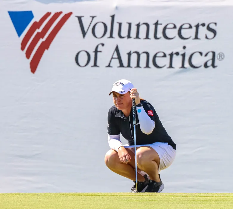 golfer with Volunteers of America signage in the background