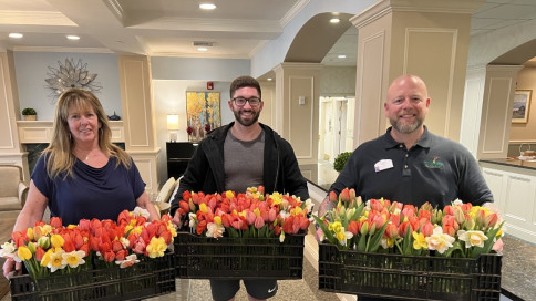 staff members holding baskets of flowers
